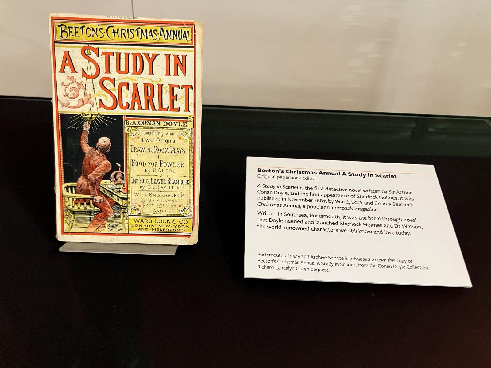 The book "Beeton's Christmas Annual A Study In Scarlet" in a display case
